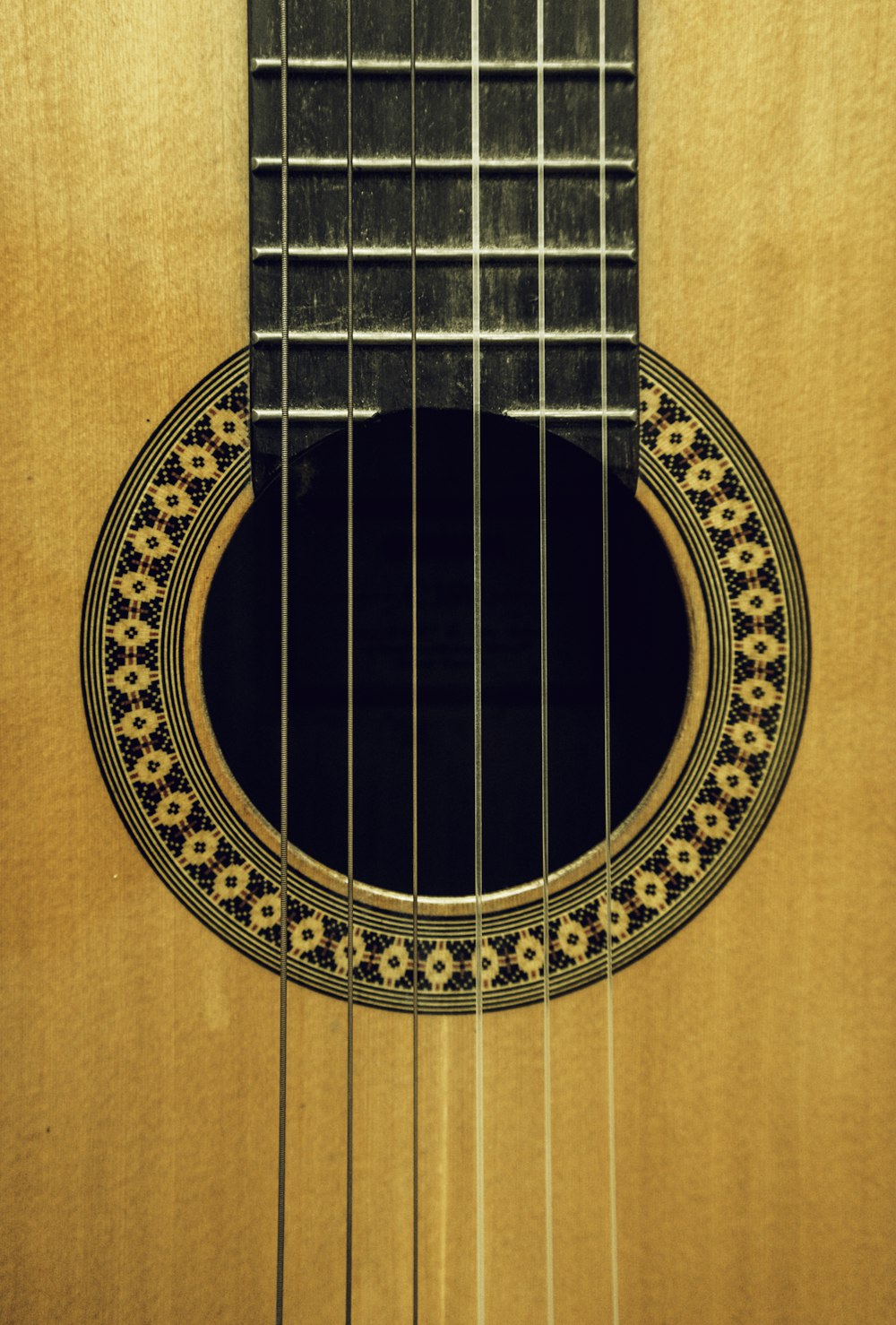 Guitarra acústica marrón sobre mesa de madera marrón