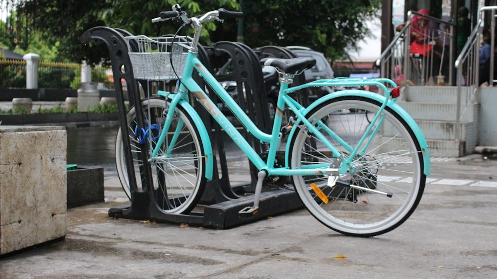 blue city bike parked beside black metal fence during daytime