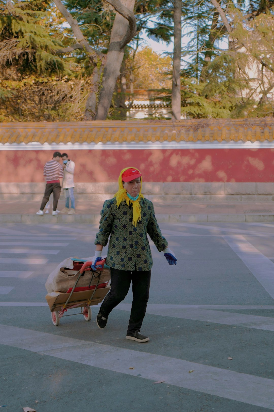 girl in green jacket and black pants walking with a dog on the street during daytime