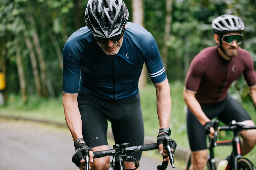 man in blue long sleeve shirt and black shorts riding black bicycle