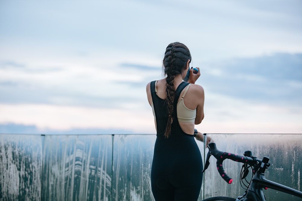 woman in black tank top and black leggings holding black camera