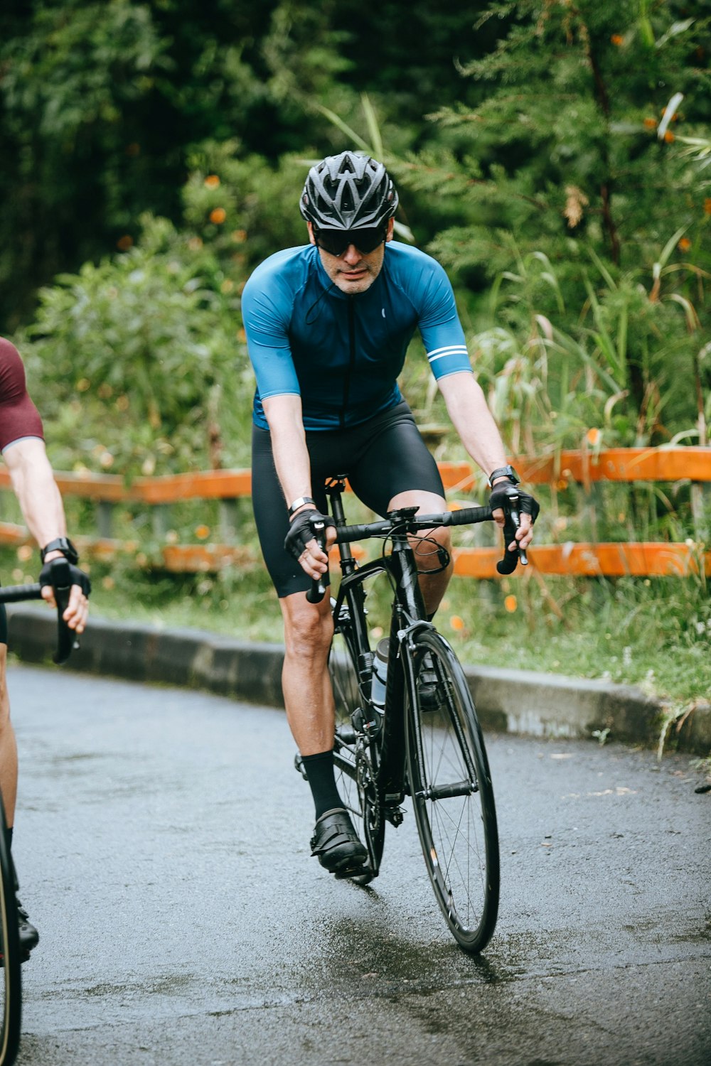 man in blue crew neck t-shirt riding black bicycle on road during daytime