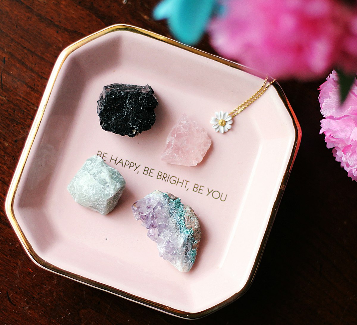 Black and white healing crystals arranged on a white ceramic tray, contrasting dark protective stones with lighter companion crystals