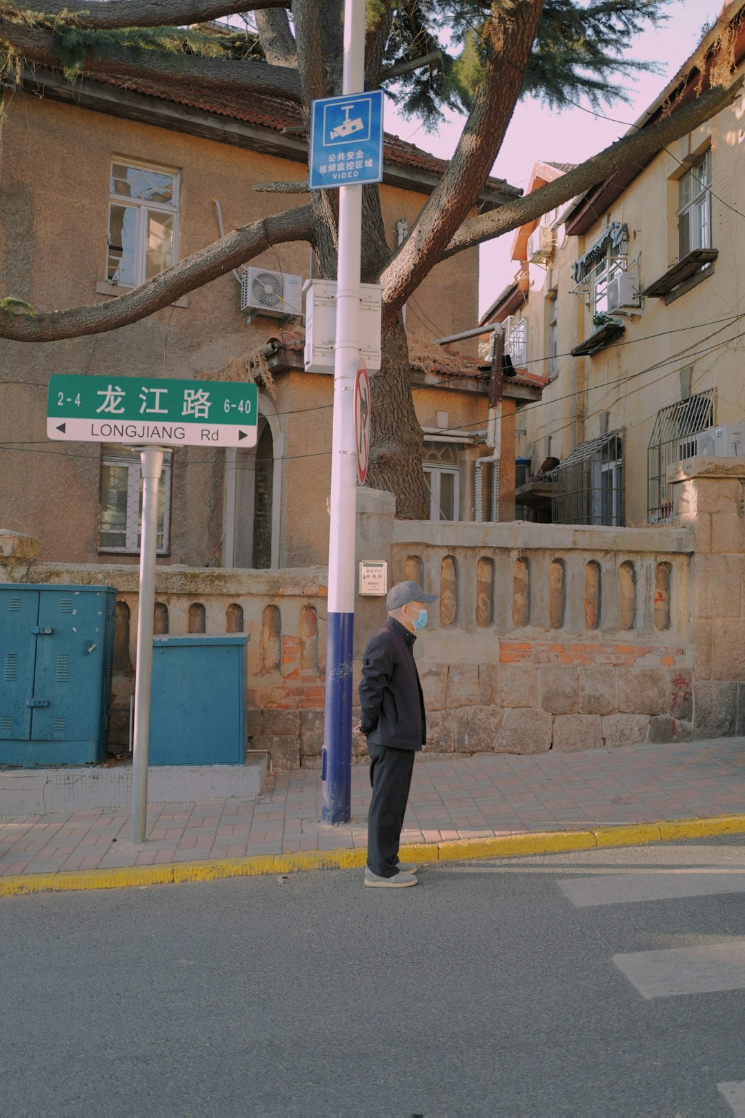 man in black suit standing on sidewalk during daytime