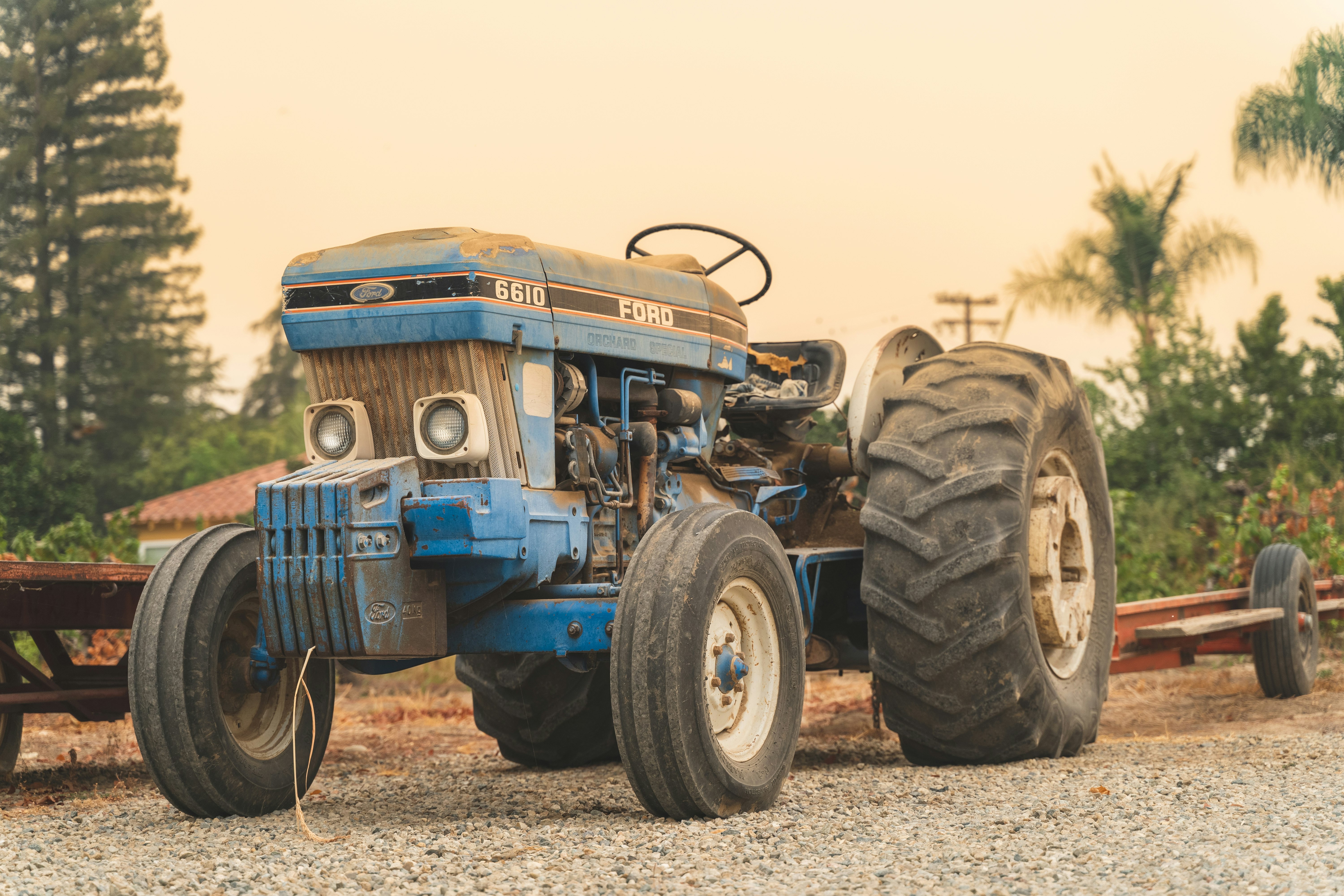 blue tractor on brown field during daytime