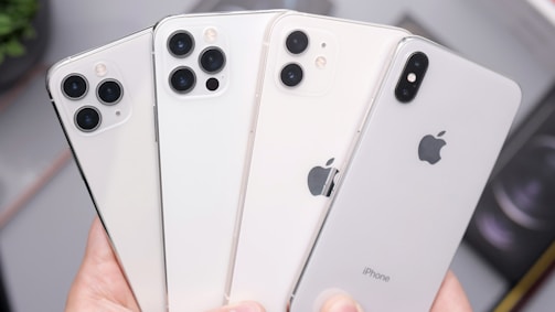 a person holding four iphones in their hands