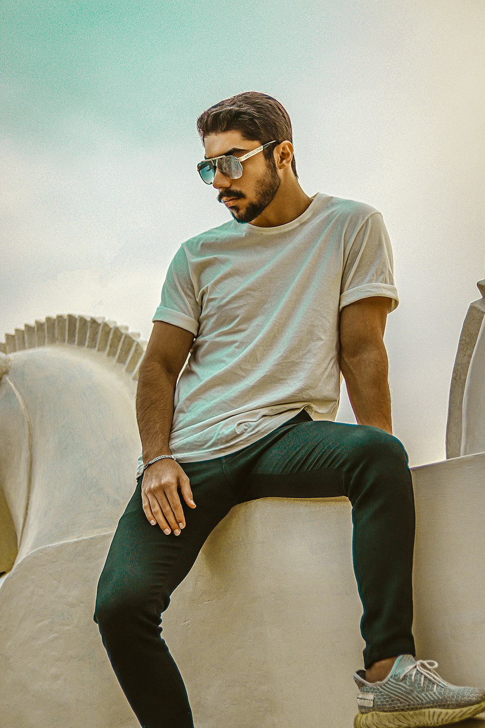 man in white crew neck t-shirt and black pants sitting on white couch