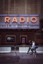 people walking on sidewalk near brown and white building during daytime