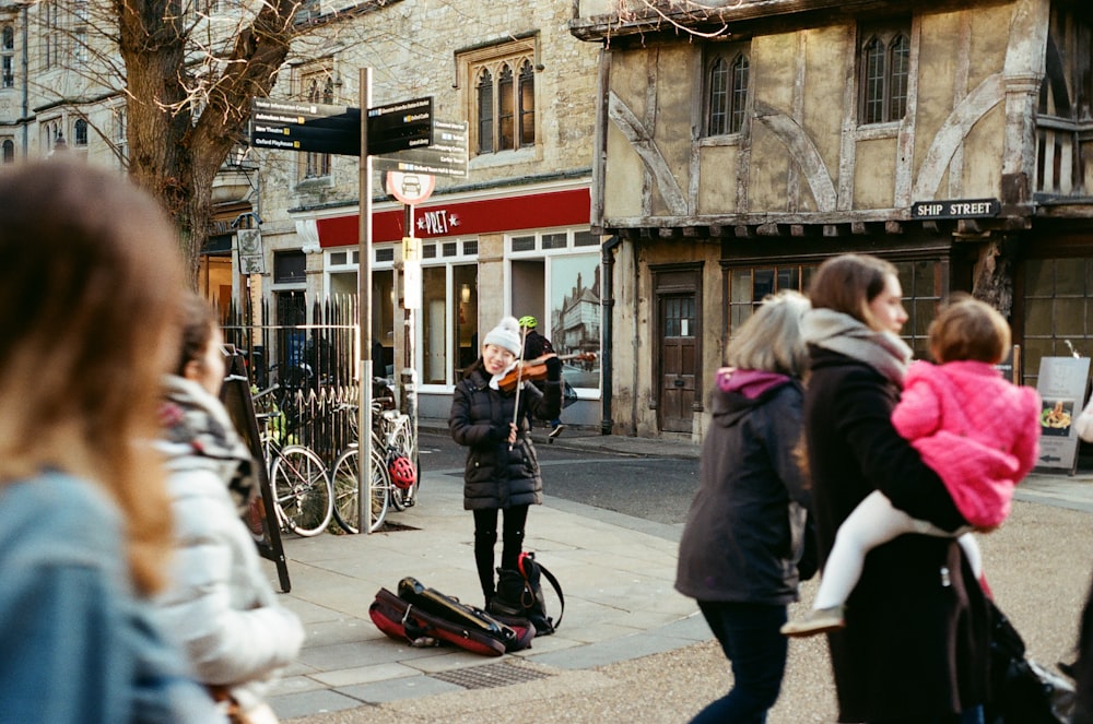 woman in white coat and black pants walking on street during daytime