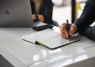 person writing on white paper