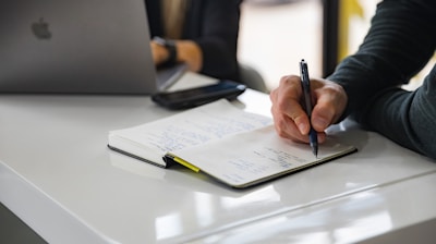 person writing on white paper