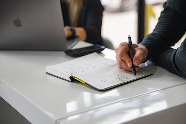 Person working on a digital marketing strategy with a notebook and smartphone.