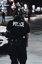 man in black and white adidas jacket and black helmet standing on road during daytime