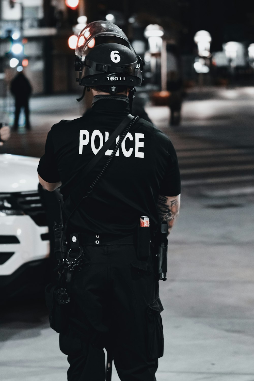 man in black and white adidas jacket and black helmet standing on road during daytime