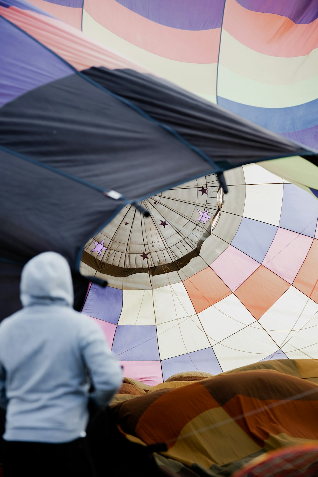 man in white thobe sitting on blue and yellow hot air balloon