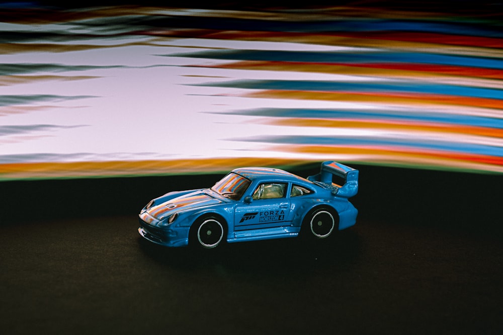 blue porsche 911 on black pavement