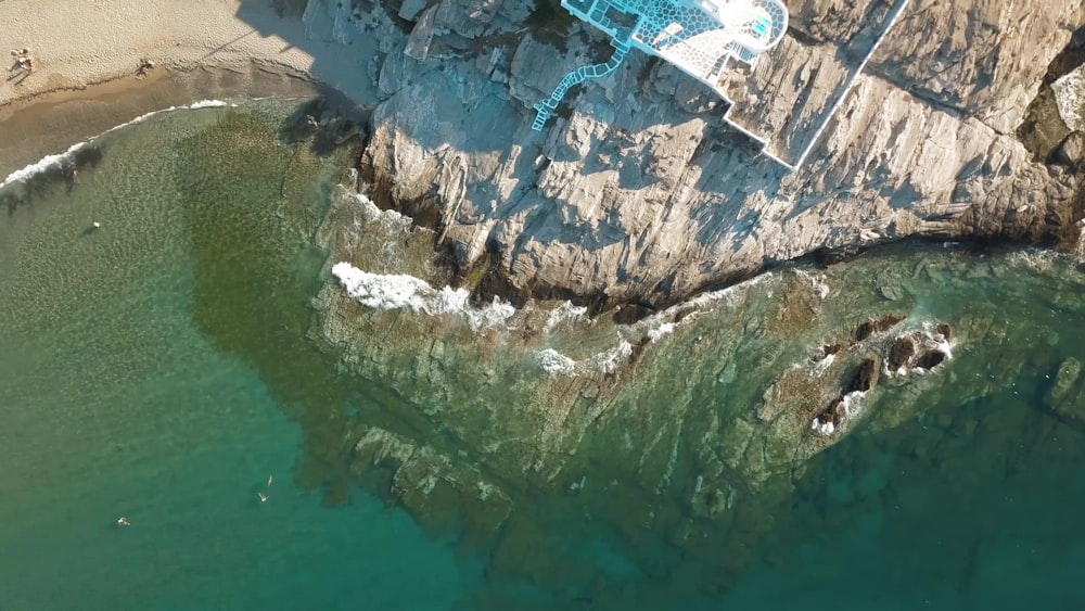 aerial view of gray and white rock formation beside body of water during daytime