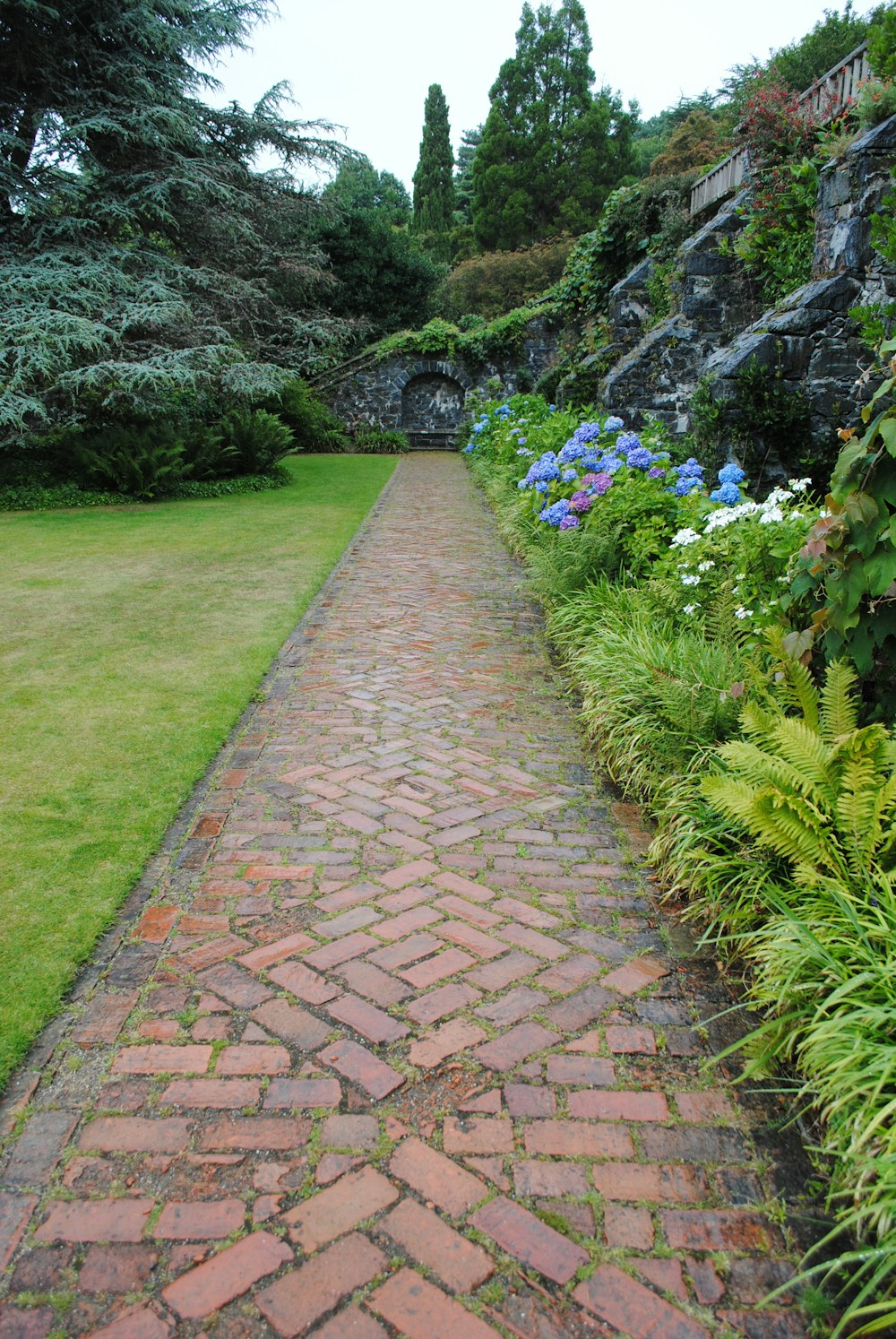 brown brick pathway between green grass field