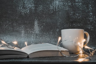white ceramic mug on book page