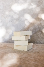 Bars of syndet soap stacked neatly with soft lighting highlighting their smooth texture.