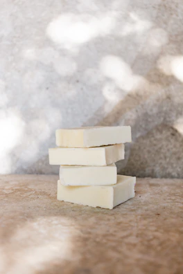 Freshly made soap bars stacked neatly with soft shadows