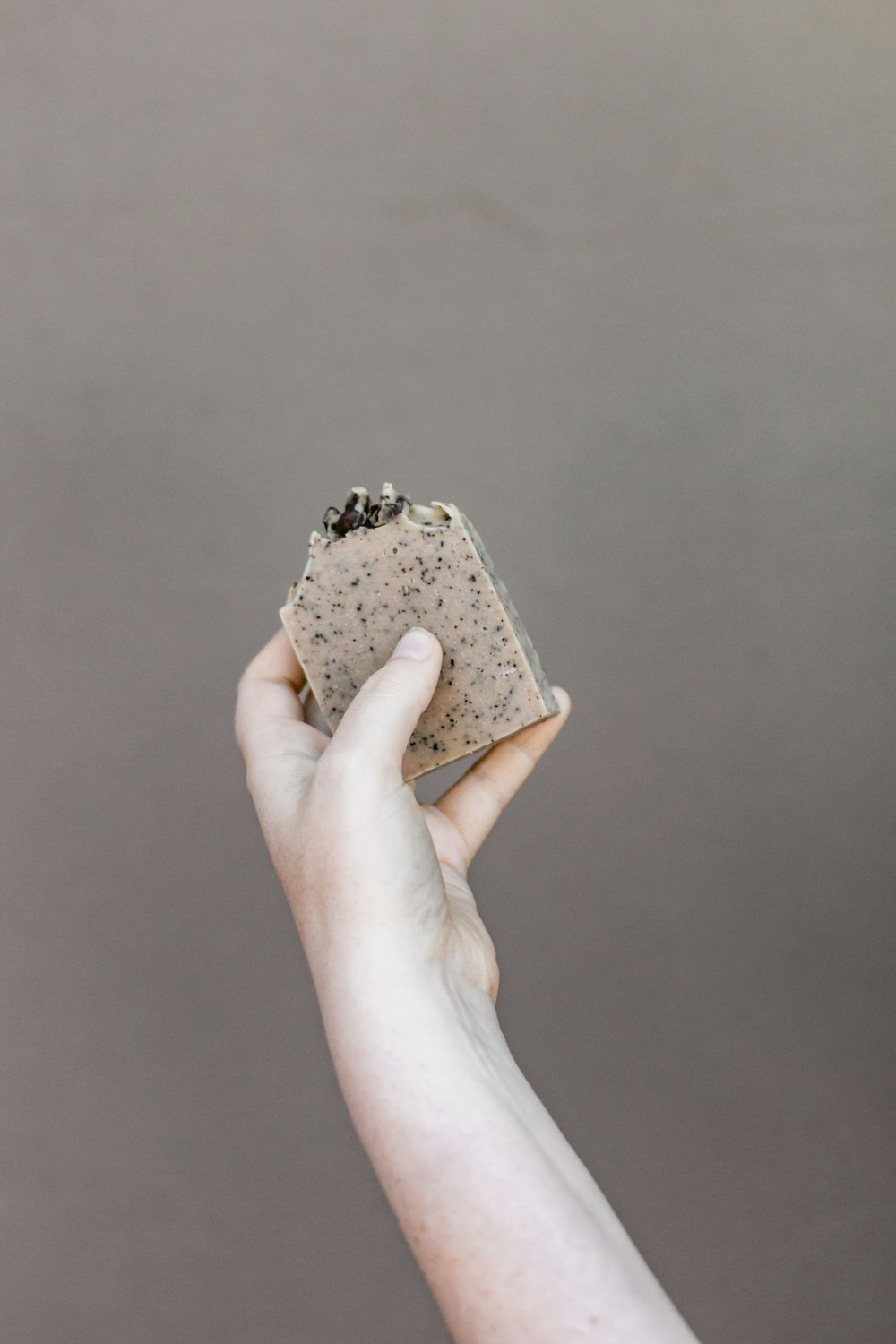 person holding brown and black floral case