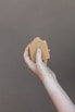 Close-up of hands mixing natural soap ingredients in a rustic wooden bowl.