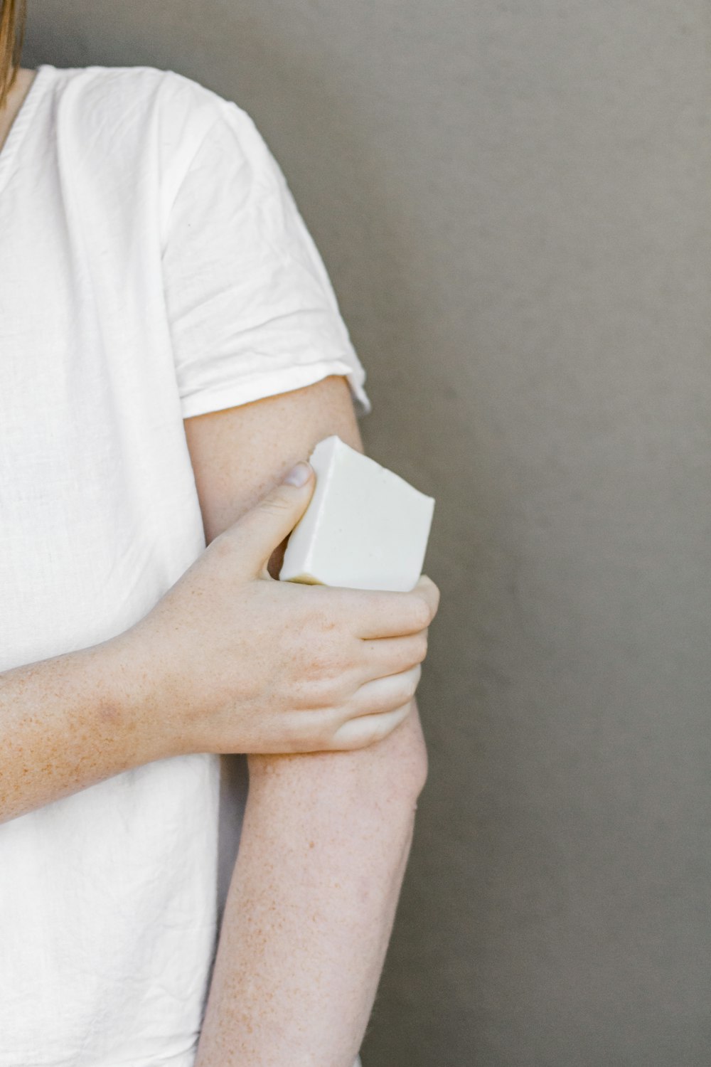 person in white t-shirt holding white box