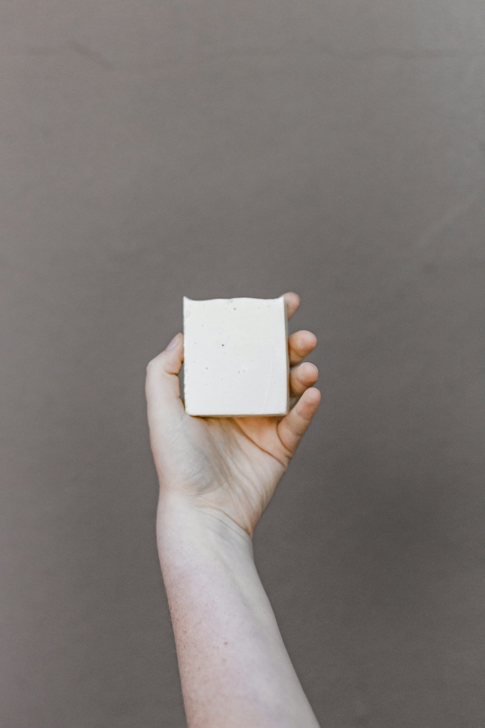 person holding white square box