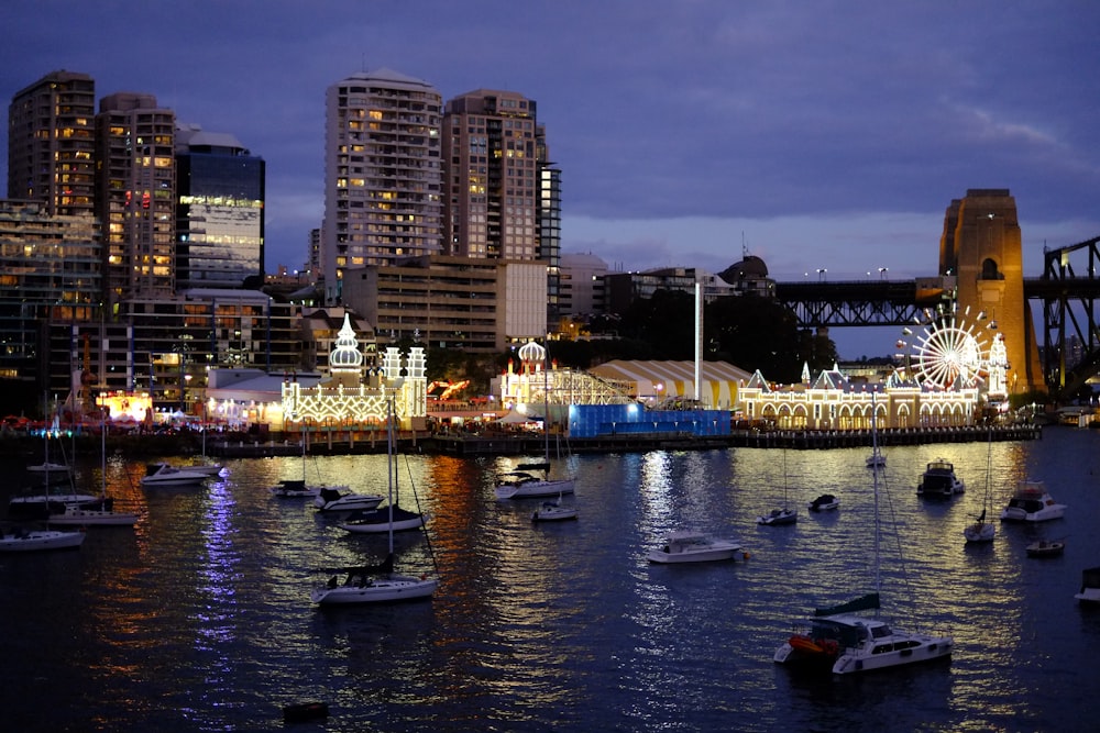 white and black boat on body of water near city buildings during night time