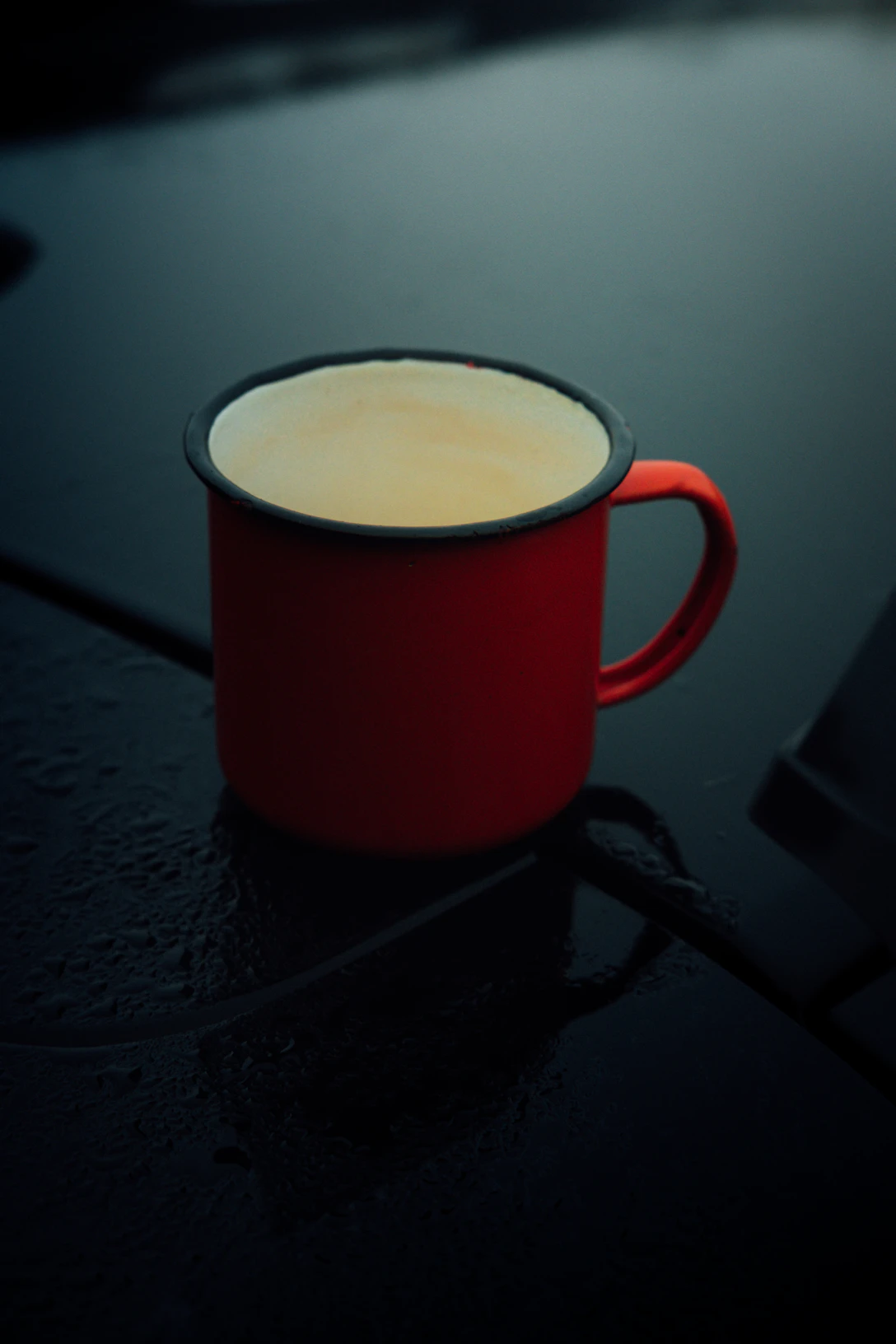 Two enamel camp mugs with red rims