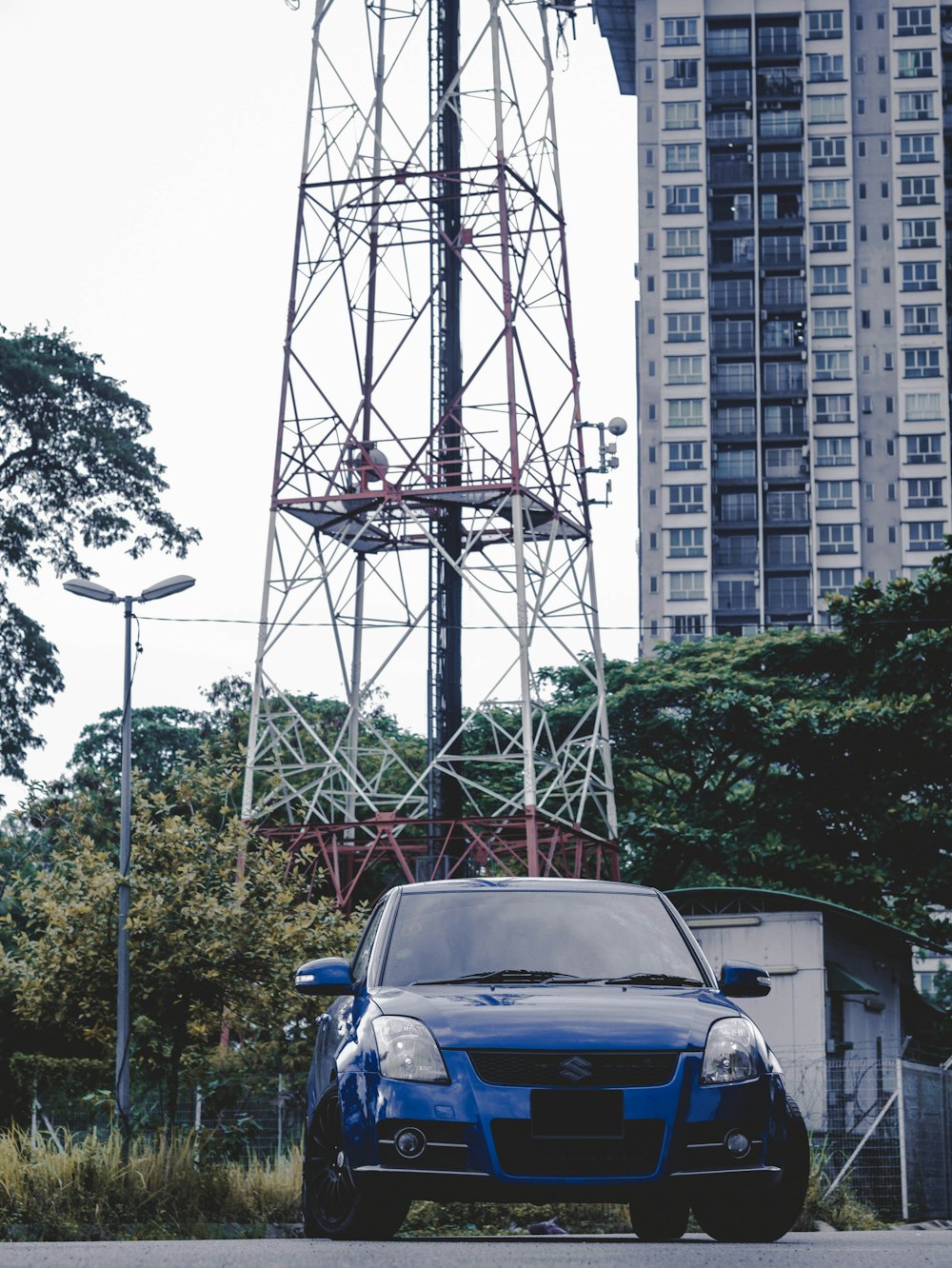 blue car parked near white building during daytime