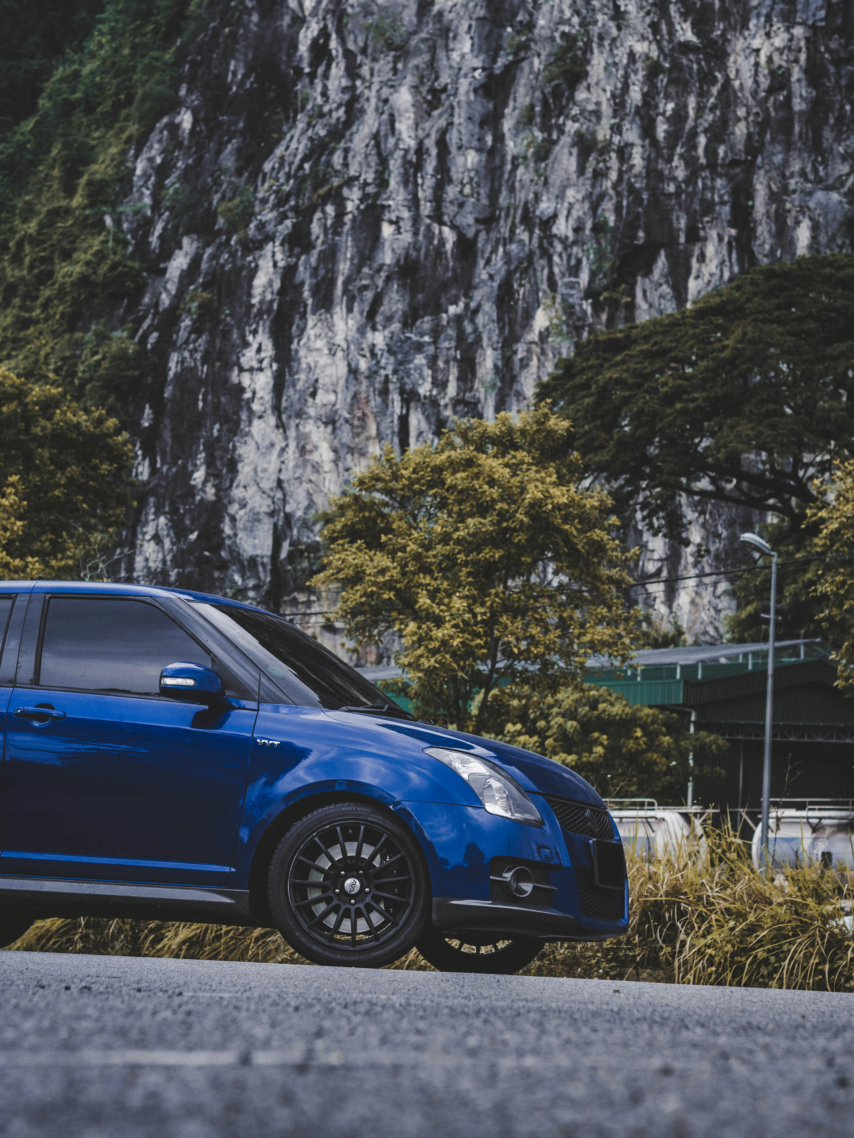 blue car parked near green trees during daytime