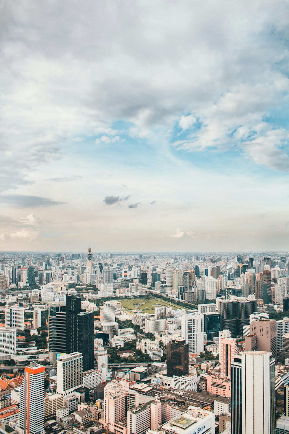 city buildings under white clouds and blue sky during daytime