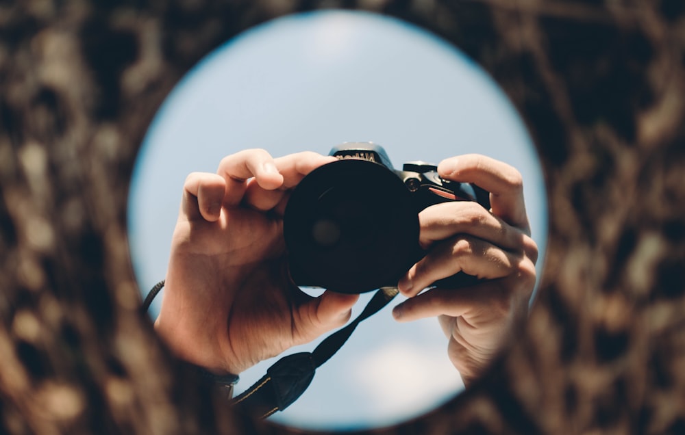 person holding black dslr camera