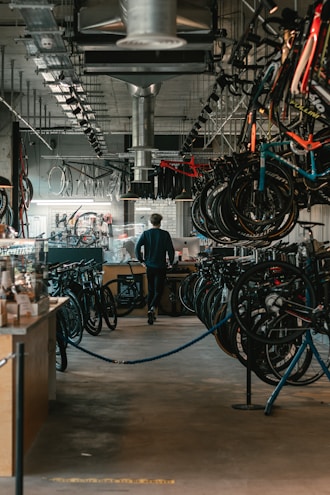 man in black t-shirt standing near black and red bicycle
