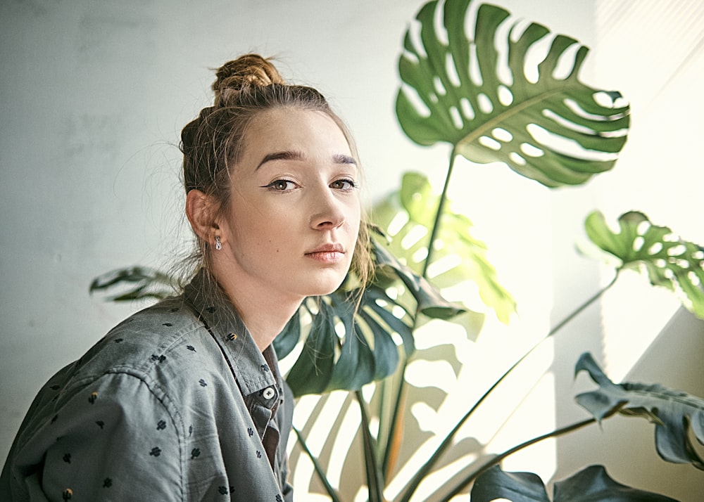 woman in black leather jacket standing near green leaves