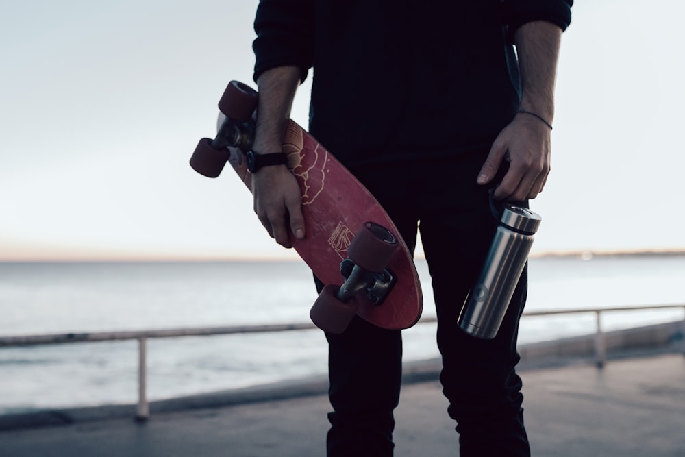 person in black shirt holding stainless steel vacuum flask