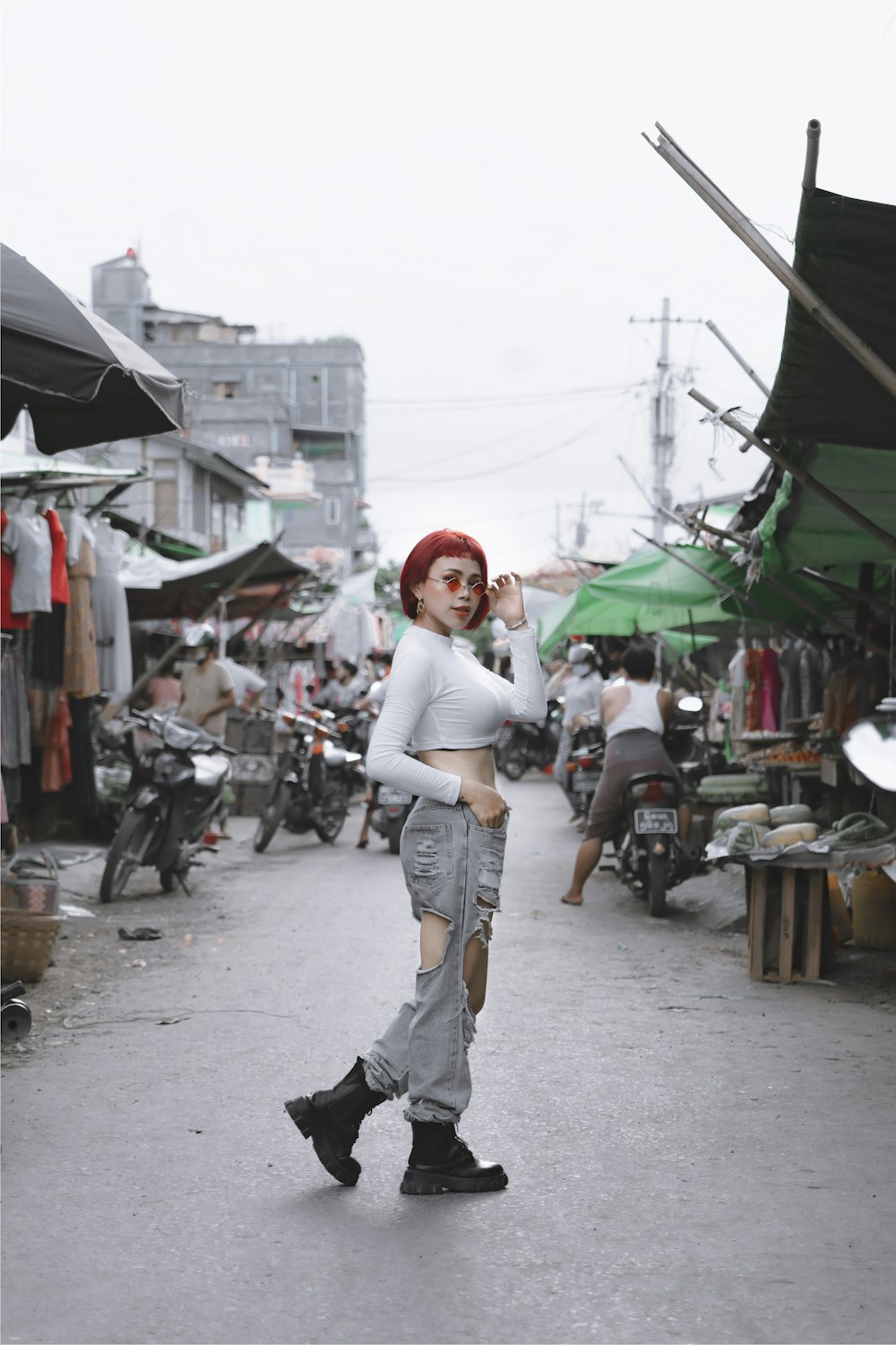 woman in white shirt and blue denim jeans walking on street during daytime