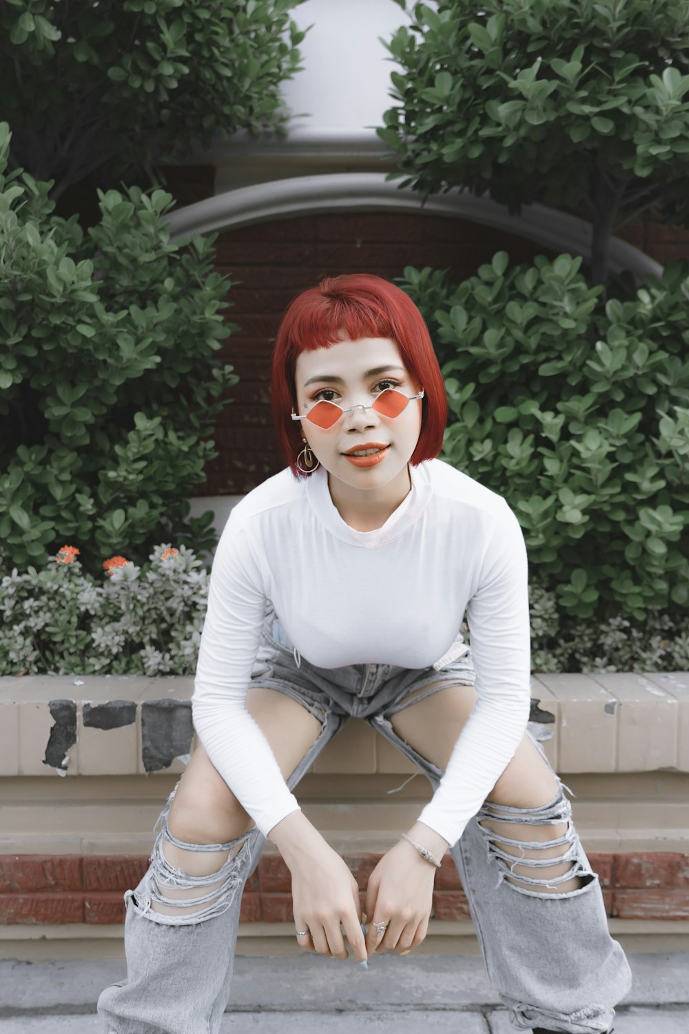 woman in white long sleeve shirt sitting on brown concrete bench