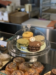 Plate of assorted cookies in shades of light brown and yellow with green leaves around