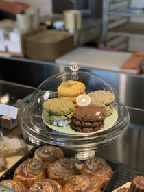Plate of assorted cookies in shades of light brown and yellow with green leaves around