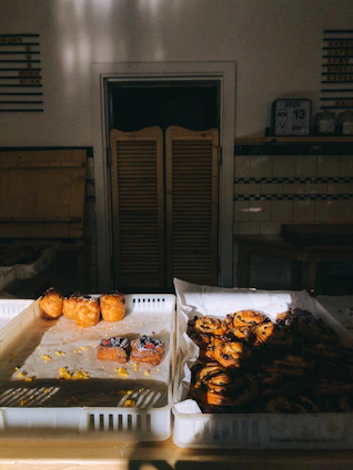 A cozy bakery kitchen with trays of gourmet sweets and savory pastries cooling on the counter.