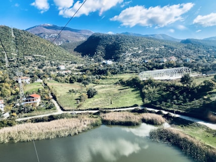 aerial view of green mountains and trees near lake during daytime