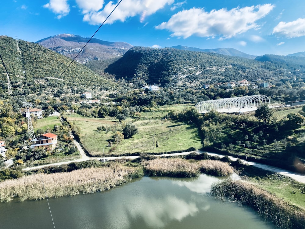 aerial view of green mountains and trees near lake during daytime