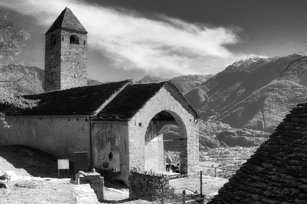 grayscale photo of concrete building near mountain range