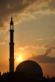 A warm sunset view of the mosque's exterior with the crescent moon above