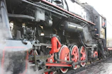 A detailed close-up of a vintage steam engine with visible gears and pistons