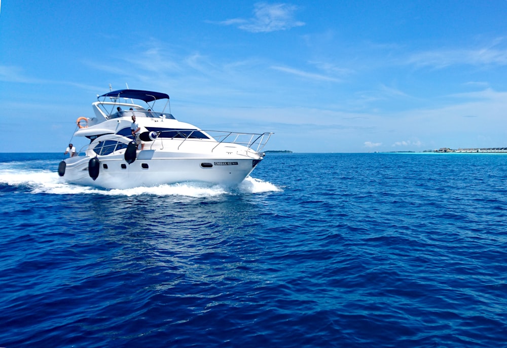 Weiße und blaue Yacht auf See unter blauem Himmel tagsüber