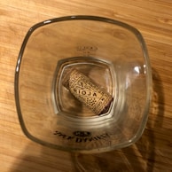 Close-up of a colorful 'Rioja and Roll' branded t-shirt on a wooden table.